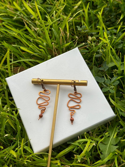 Copper swirl earrings with goldstone drop